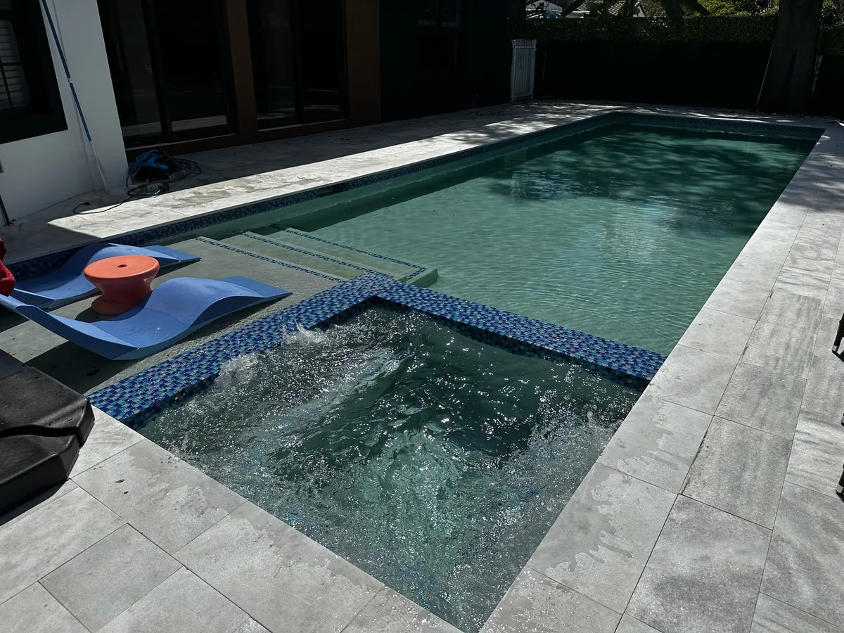 Bubbling spa with blue tile beside the pool steps