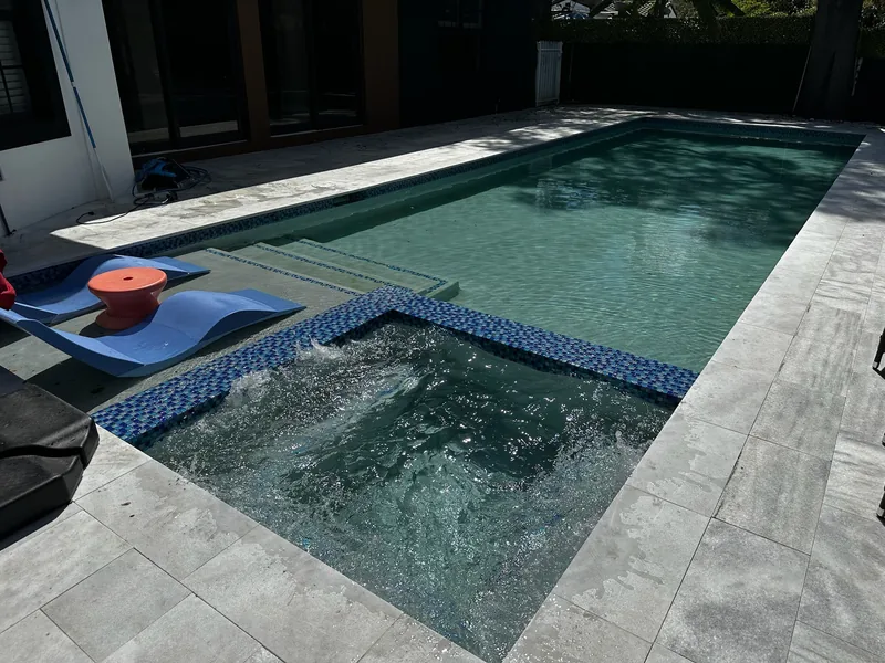 Bubbling spa with blue tile beside the pool steps