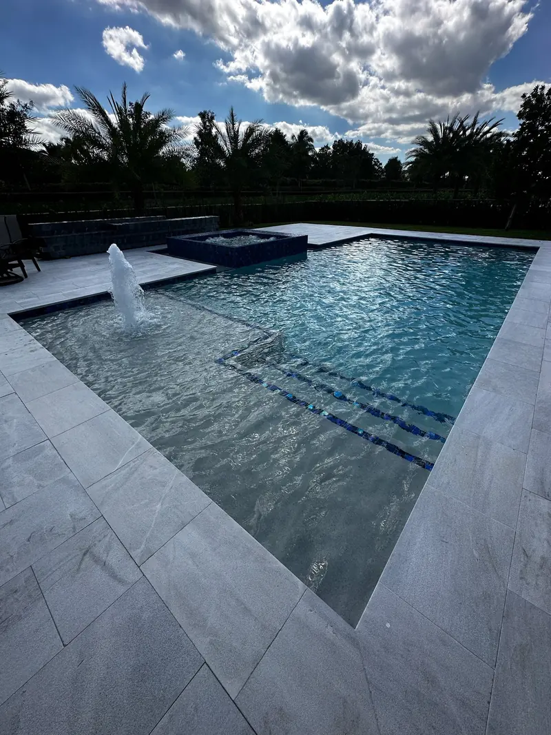 Shelf bubbler in a pool with palms and a white deck
