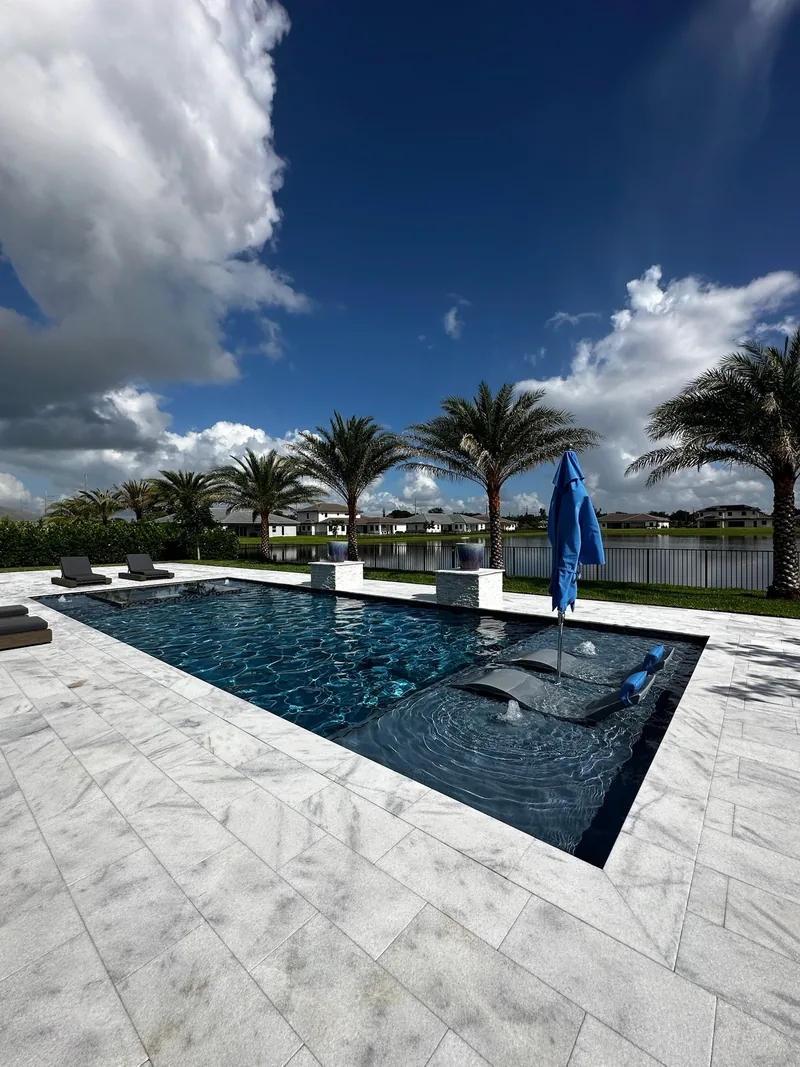 Sun shelf with an umbrella, palms and a lake beyond