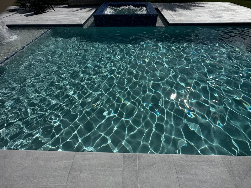 Clear turquoise water with sunlight patterns over the pool floor