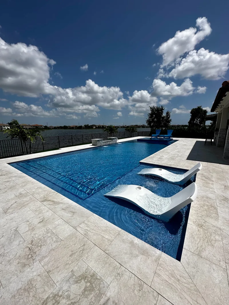 White in-pool loungers on a sun shelf with a lake view