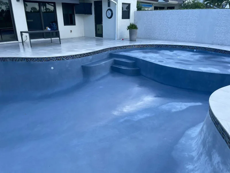 Curved pool with a built-in step and a fresh blue-grey interior finish