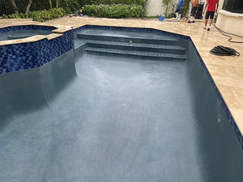 Pool with wide steps and a tiled spa behind travertine coping