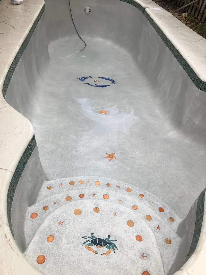 Pool steps with small inlaid mosaic crab, starfish and shell accents