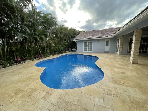 After: the back corner with the finished pool, new coping and travertine deck