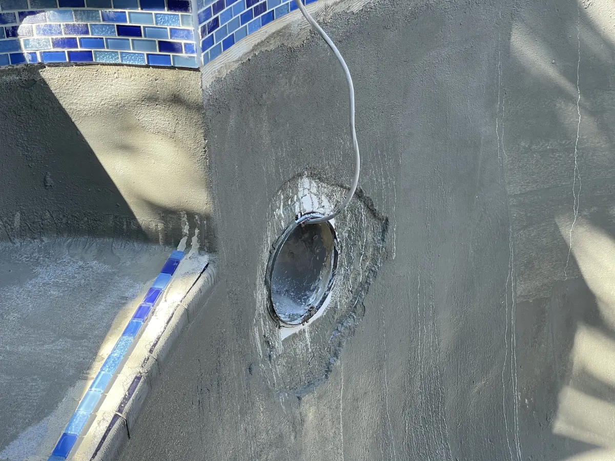 New blue glass waterline tile and a light niche on the prepared wall