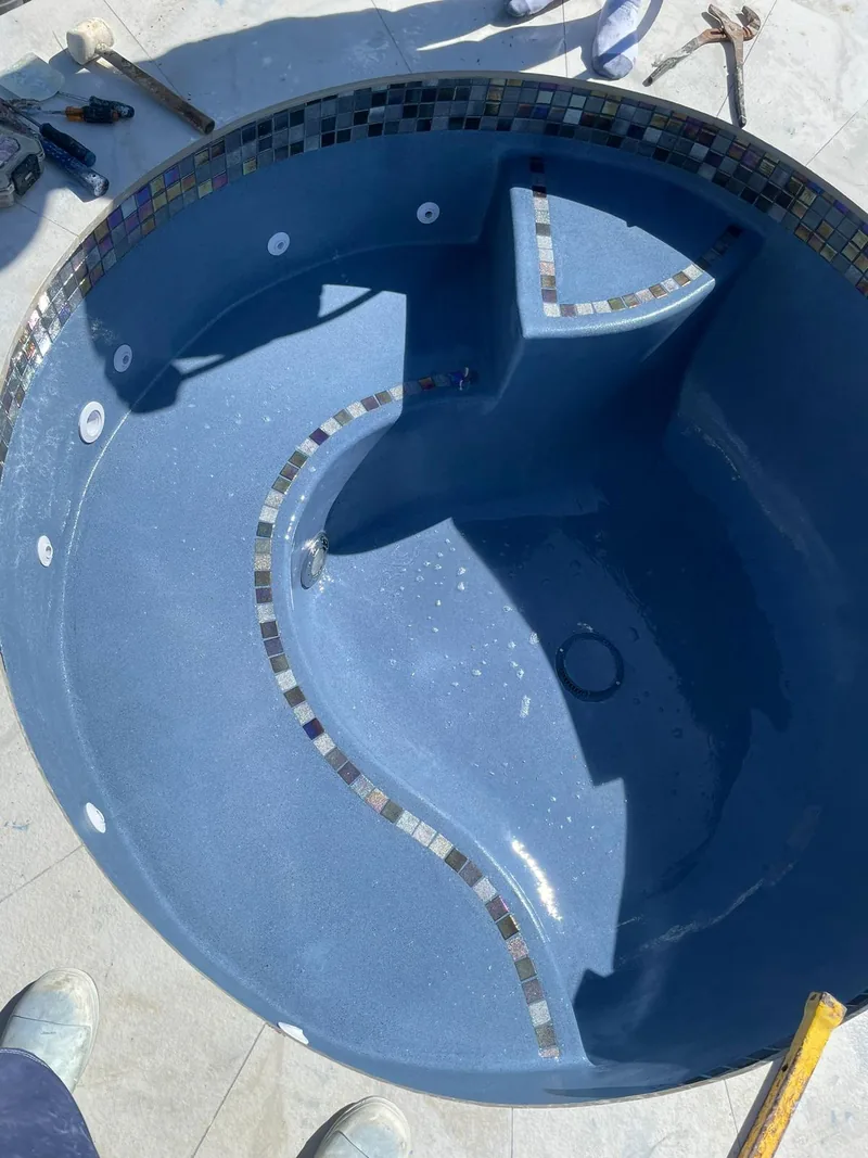 Round spa interior with a curved seat and a strip of mosaic tile accent
